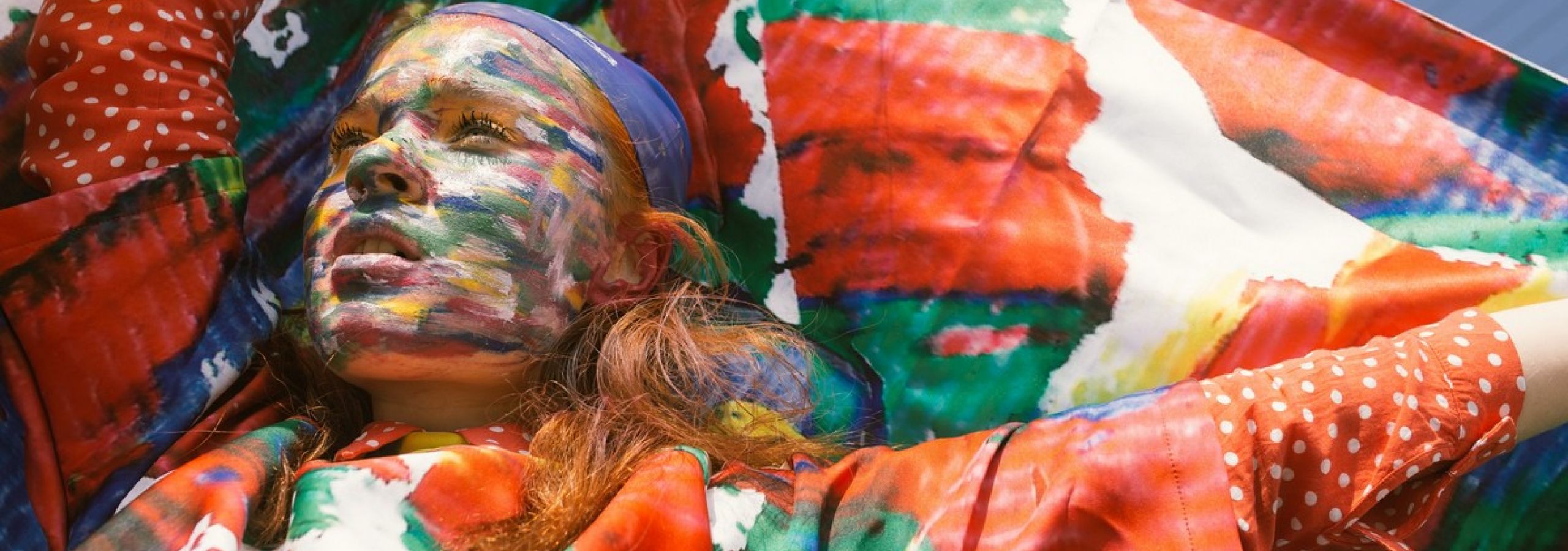 woman-with-face-paint-raising-her-hands-holding-textile-682025-54485c49 imagem